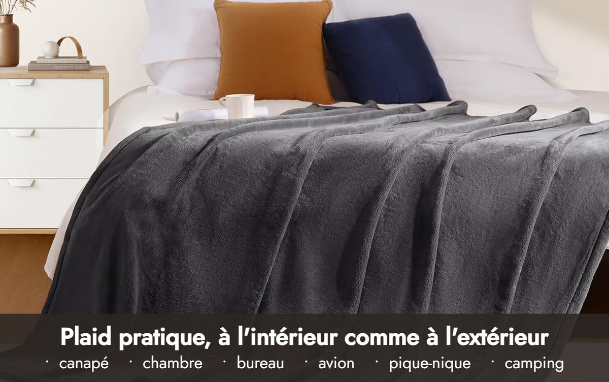 Plaid Le Velours gris sur un lit : pratique à l'intérieur comme à l'extérieur (canapé, chambre, bureau, avion, pique-nique, camping)